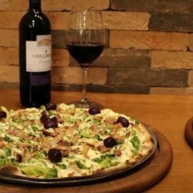 Pizza de brócolis com bacon e taça de vinho