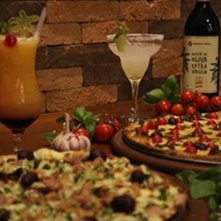 Mesa com pizzas, drinks e ingredientes