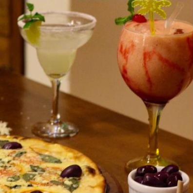 Drinks e pizza na mesa